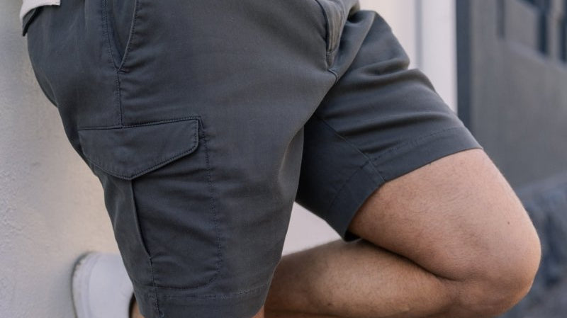 Man wearing dark cargo shorts with side pocket, close-up of fit and fabric