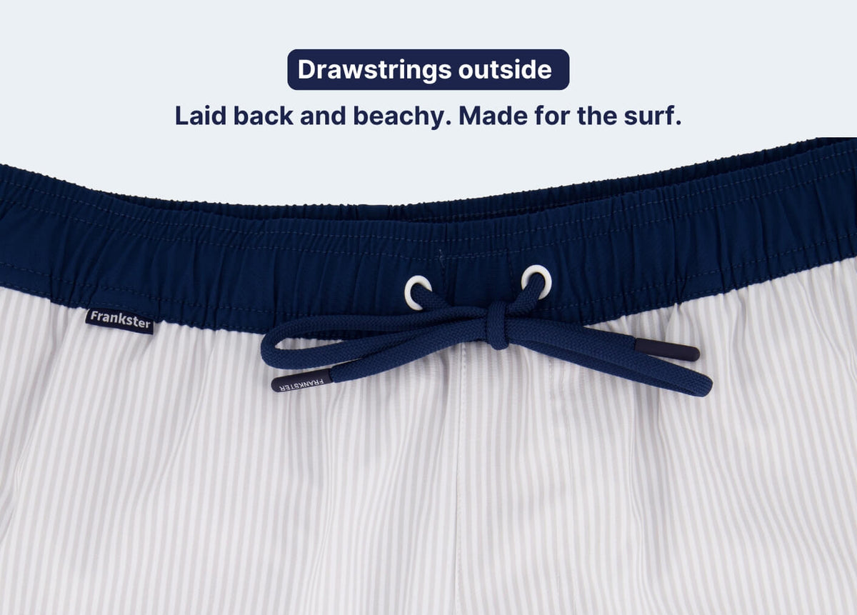 White pinstriped Men's Shorts with a navy partly elasticated waistband and external drawstring for a relaxed beachwear style