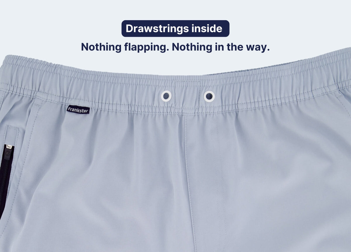 Light blue Men's Shorts close-up showing a partly elasticated waistband and concealed internal drawstring in smooth lightweight fabric