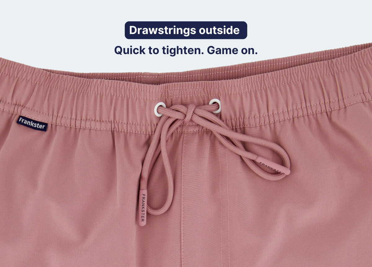 Close up of dusty pink Men's Shorts with an elastic waistband and external drawstrings highlighted for quick tightening