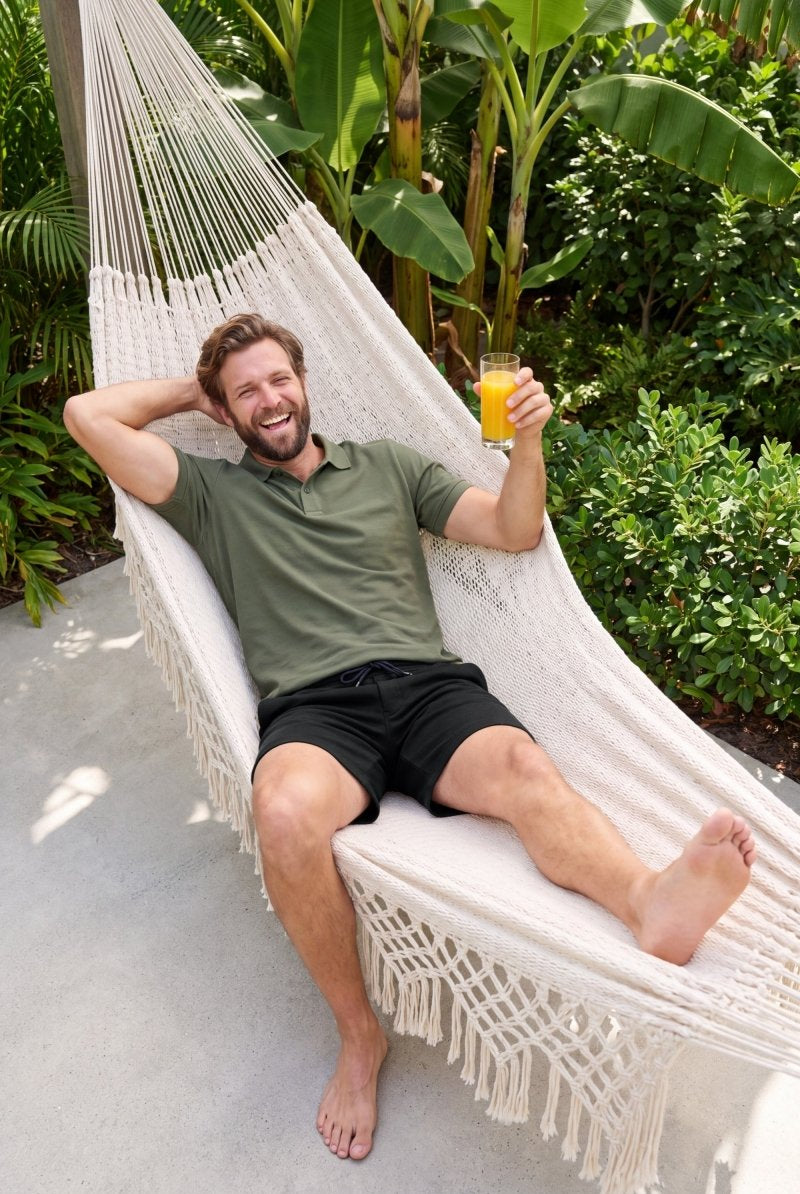 Frankster Midnights * The Comfies black Men's Shorts in fabric worn by a man relaxing in a hammock outdoors