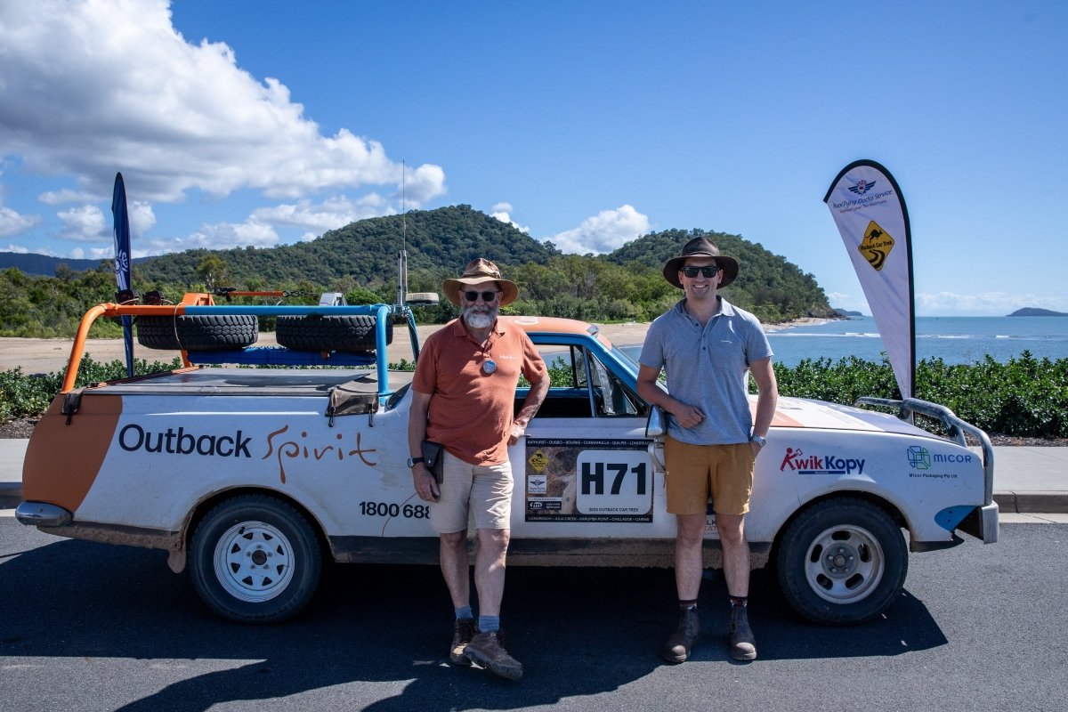 2 aussie blokes, a father and his son, standing in front of a car. Both dressed in different types of men's shorts