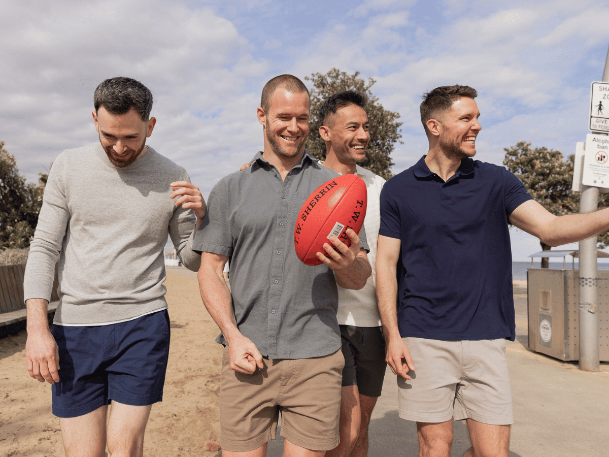 Four men in a mixture of frankster shorts with a football, enjoying the Australian sun.