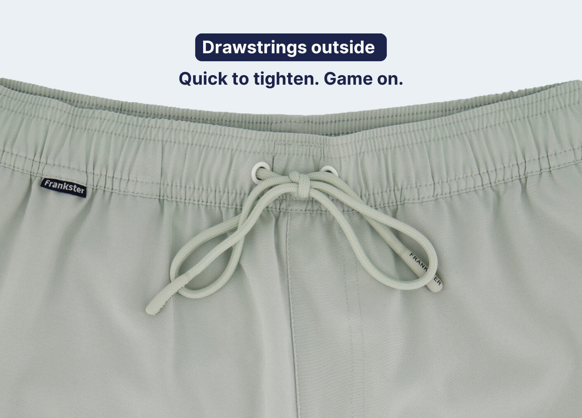 Men's Shorts in light sage fabric with a partly elasticated waistband and external drawstrings shown in close-up