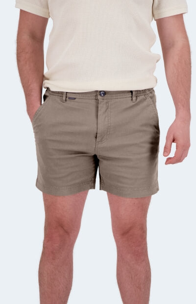 Taupe fabric Men's Shorts with a button fly and side pockets worn by a man against a plain light background