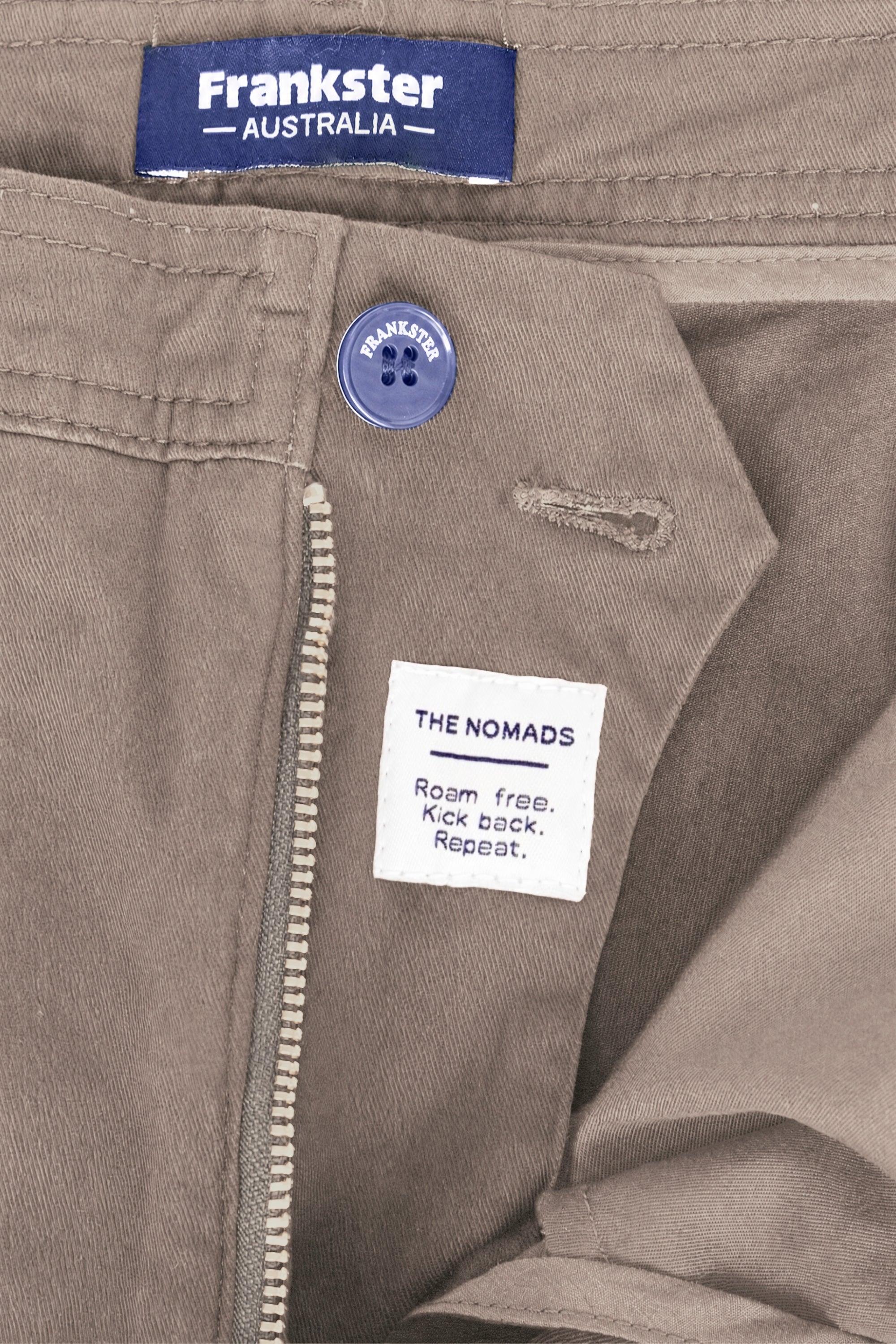 Close-up of taupe men's shorts by Frankster showing premium cotton fabric with a zipper and button closure, part of the Nomads * The Everydays collection.