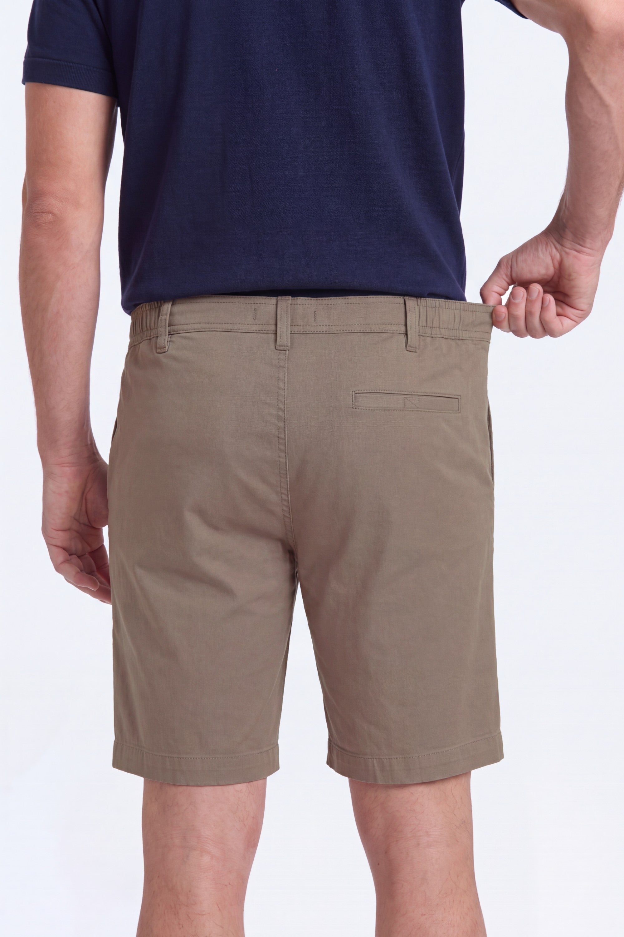 A man wearing khaki cotton blend men's shorts from Frankster, showcasing the stretchable waistband of Nomads * The Everydays shorts designed for comfort.