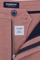 Close-up of Frankster Sundowners * The Everydays men's shorts in dusty rose colour, featuring cotton fabric, navy button and zipper detail, and inner navy lining.
