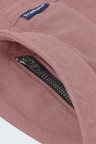 Close-up of dusty pink men's shorts fabric showing a black YKK zipper on a hidden pocket, designed by Frankster for Sundowners * The Everydays, highlighting soft, durable material ideal for comfortable wear.