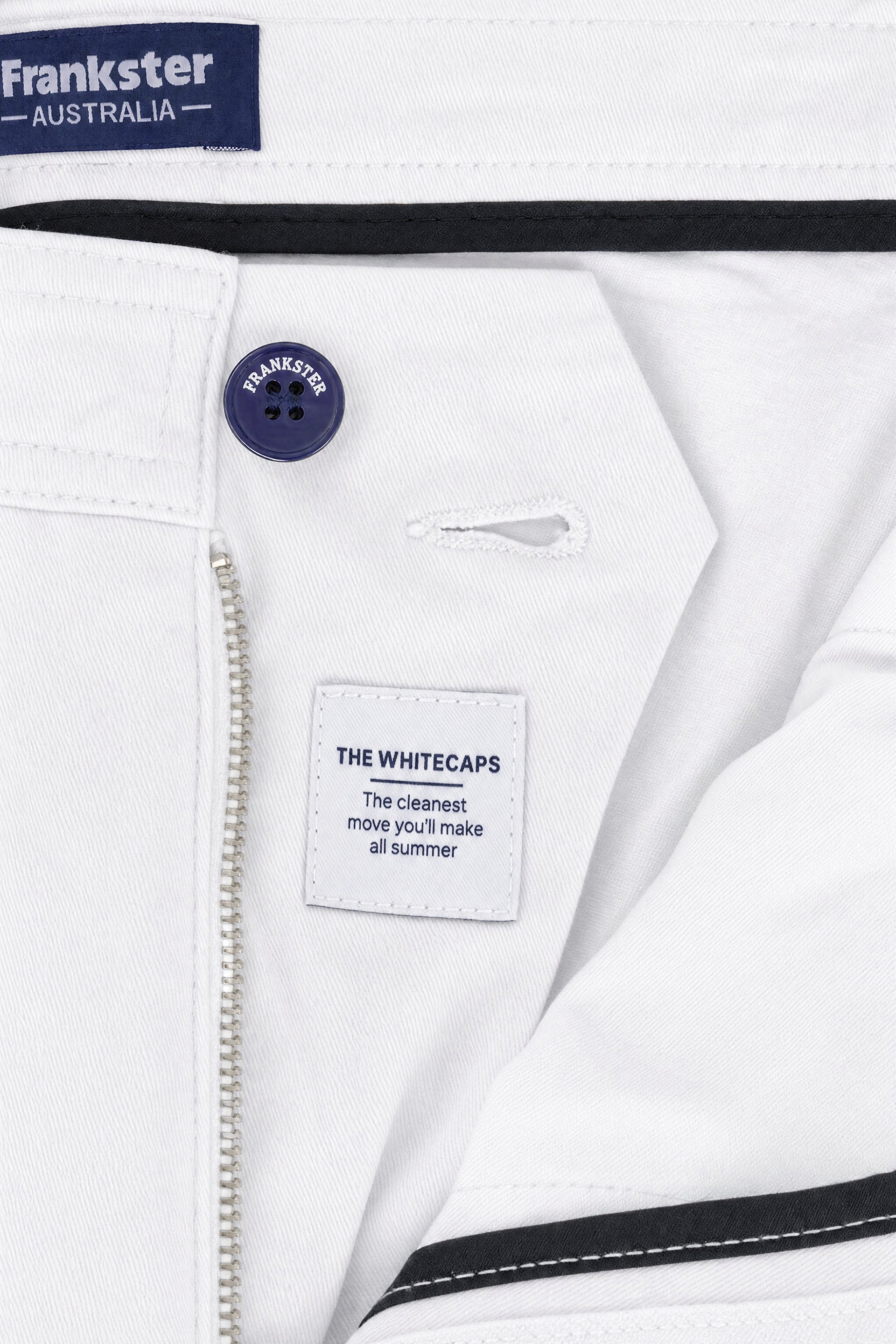 Close-up of white cotton men's shorts from Frankster, featuring a navy branded button and a clean, minimal design from the Whitecaps * The Everydays collection.