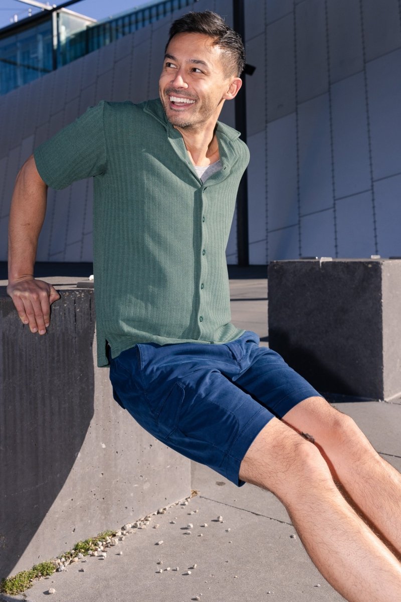 Man wearing Frankster Chillers * The Aussies dark blue premium cotton men's cargo shorts sitting outdoors on a sunny day