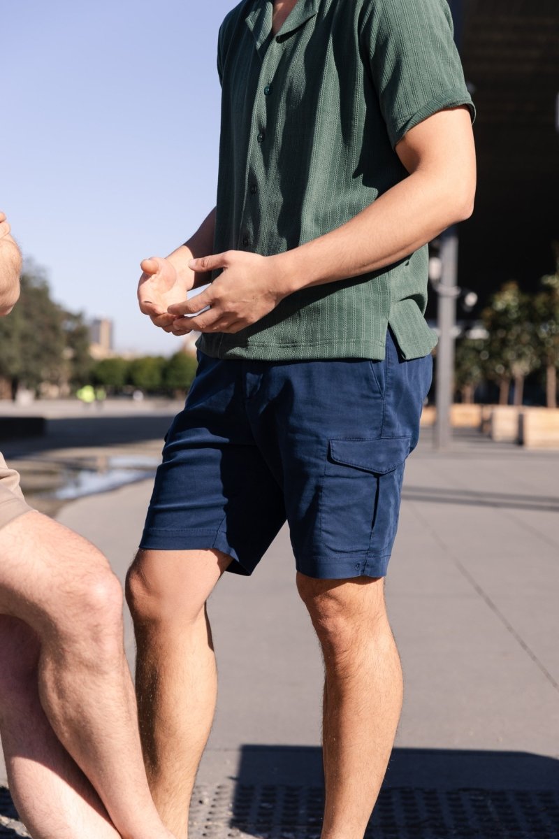 Man wearing Frankster Chillers * The Aussies dark blue cotton men's cargo shorts outdoors in casual setting