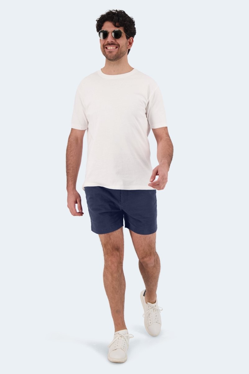 Man wearing Frankster Chillers * The Shorties dark blue stretch cotton men's shorts with white t-shirt and sneakers walking