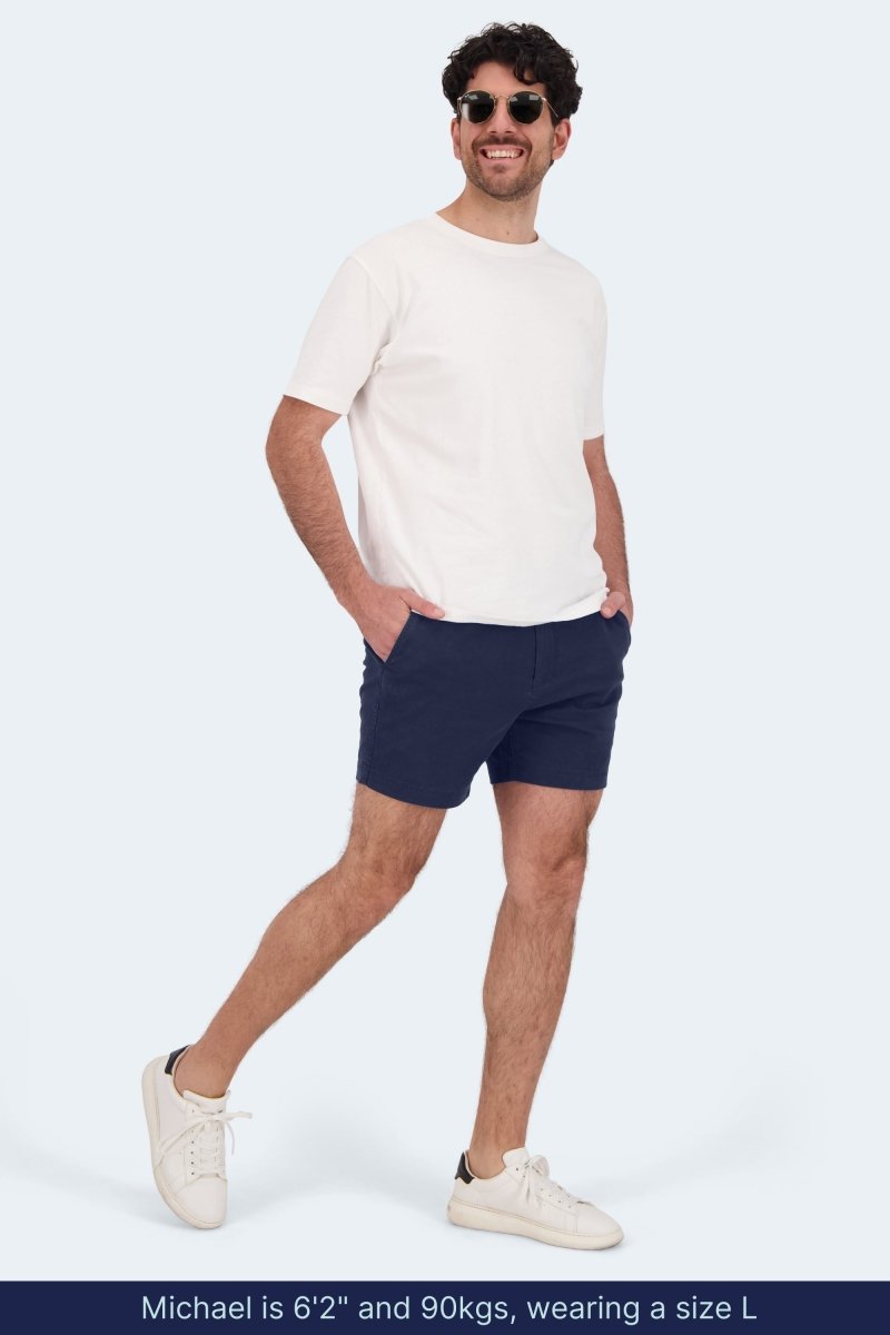 Man wearing Frankster Chillers * The Shorties dark blue stretch cotton men's shorts with white t-shirt and sneakers