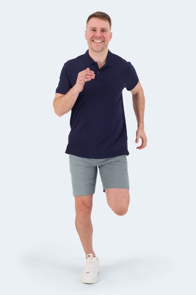 Man wearing Frankster Coastlines * The Actives men's shorts in blue grey lightweight fabric paired with a navy polo shirt