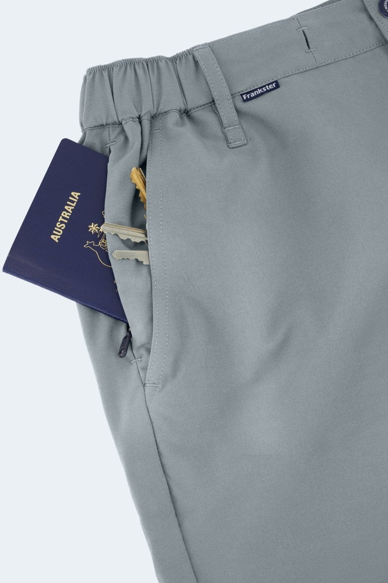 Close-up of Frankster Coastlines * The Actives men's shorts in blue grey lightweight fabric with elastic waistband and zippered pocket holding keys and passport