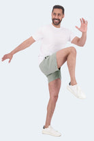 Frankster Evergreens * The Sporties Men's Shorts in light sage green fabric, modelled by a man in a dynamic pose