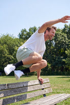 Evergreens * The Sporties by Frankster Men's Shorts in sage green woven fabric shown in motion outdoors as versatile Shorts for Men
