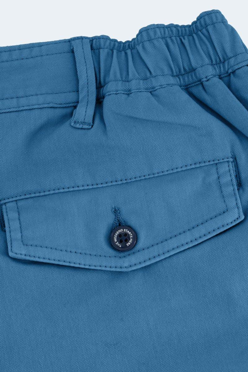 Close-up of blue cotton fabric pocket with button on Frankster Harbors * The Shorties men's shorts featuring elastic waistband detail