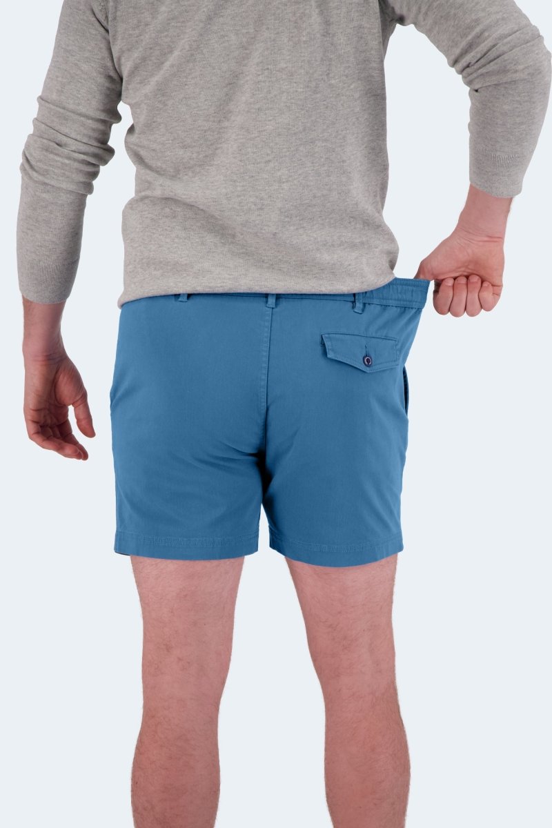 Man wearing blue stretch cotton men's shorts by Frankster Harbors * The Shorties pulling waistband to show fit