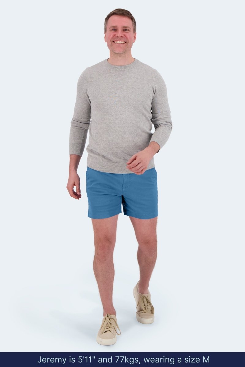 Man wearing Frankster Harbors * The Shorties men's shorts in mid blue stretch cotton walking and smiling