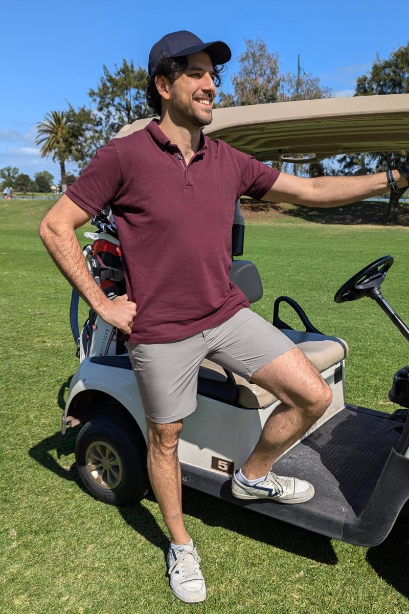 Man wearing light grey Lunars * The Actives men's shorts by Frankster standing next to a golf cart outdoors on sunny day