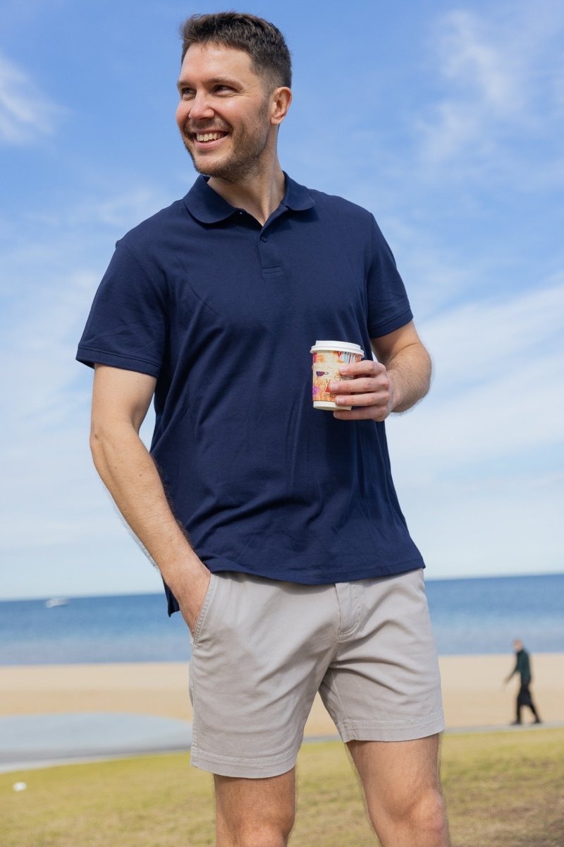 Man wearing light grey stretch cotton Lunars * The Shorties men's shorts by Frankster outdoors by the beach