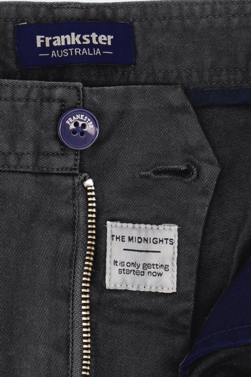 Close-up of Frankster Midnights * The Shorties black stretch cotton men's shorts showing button, zipper, and labels inside waistband