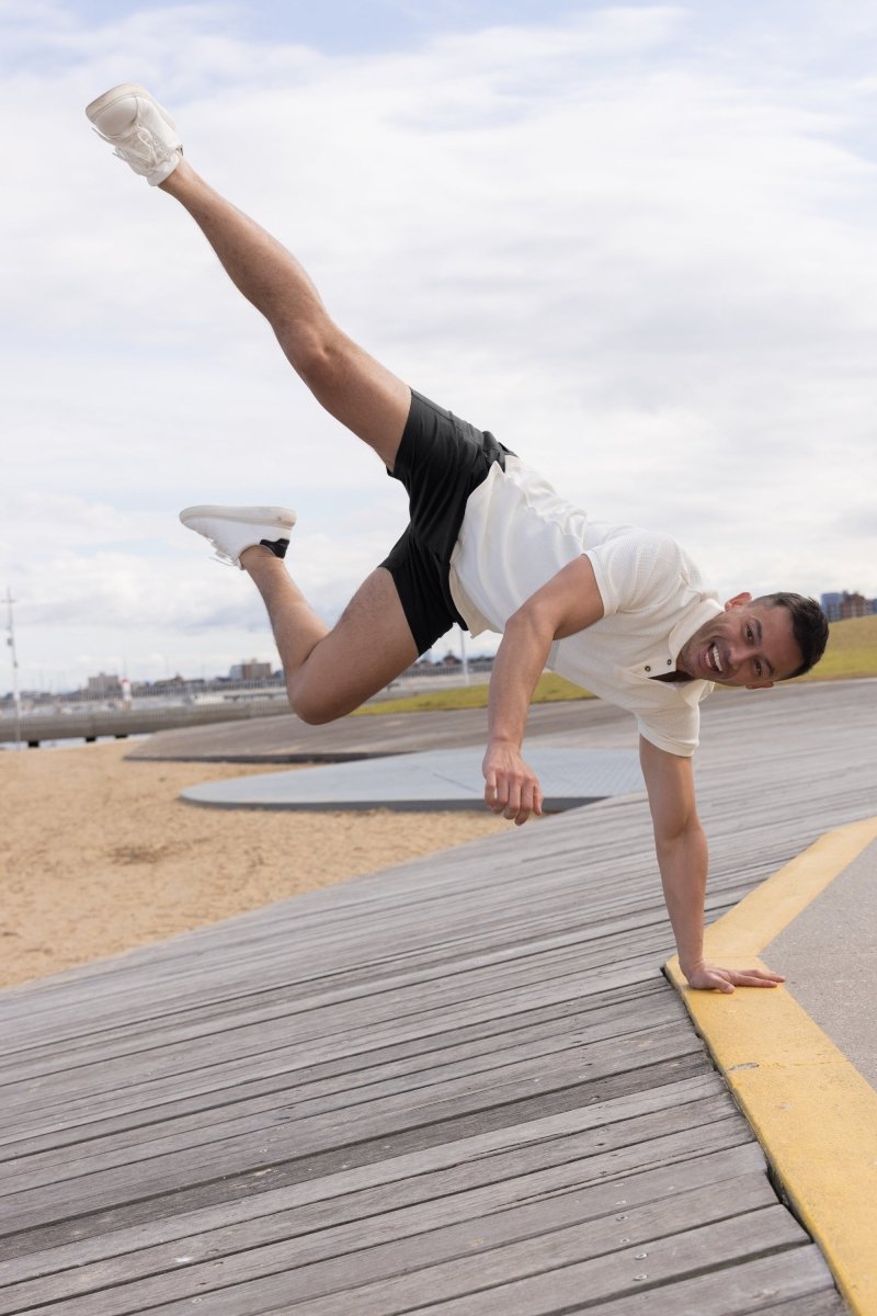 Man wearing Frankster Midnights * The Shorties black stretch cotton men's shorts performing handstand outdoors