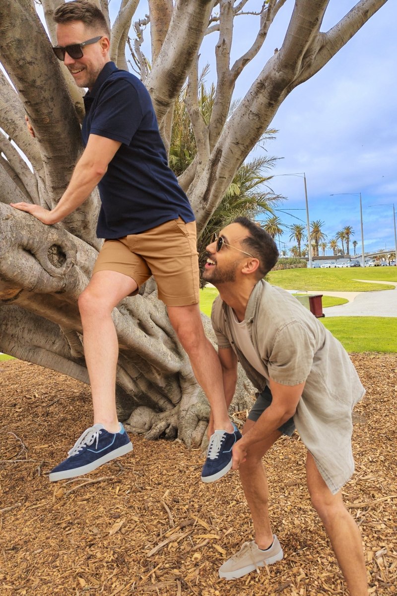 Man wearing Frankster brown stretch cotton Mokas * The Everydays men's shorts climbing tree outdoors with friend nearby