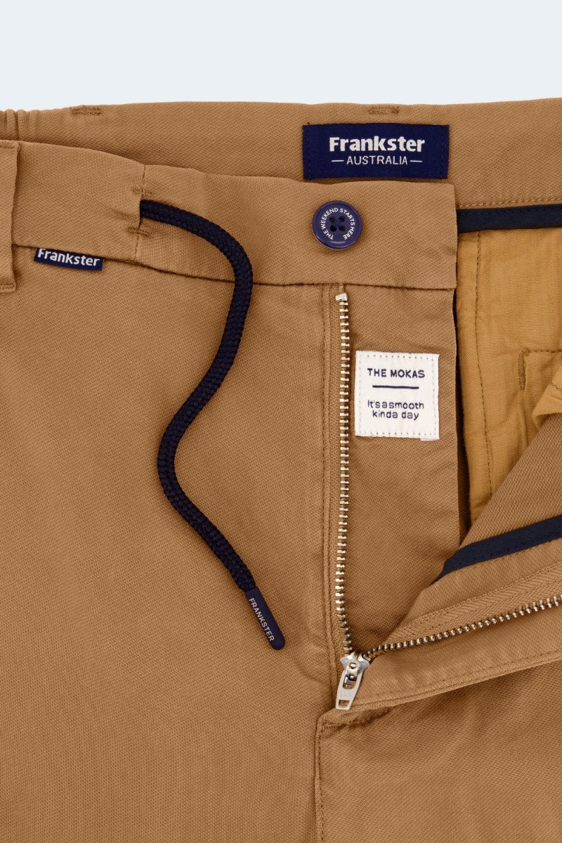Close-up of Frankster Australia men's shorts in brown cotton fabric featuring Mokas * The Aussies with zipper and button details