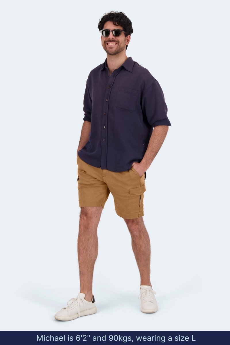 Man wearing brown Frankster Mokas * The Aussies men's cargo shorts in cotton with navy shirt and white sneakers