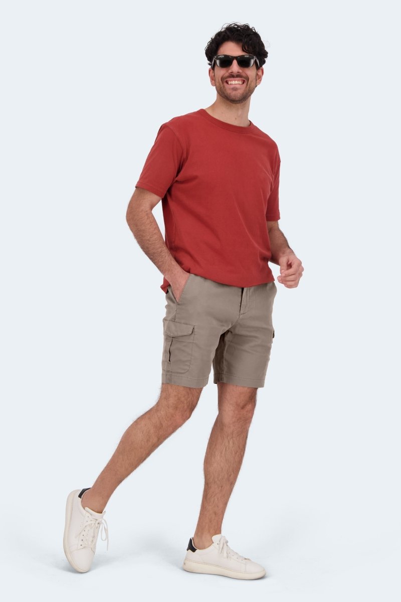 Man wearing Nomads * The Aussies Frankster dark khaki cotton men's cargo shorts with a red tshirt and white sneakers