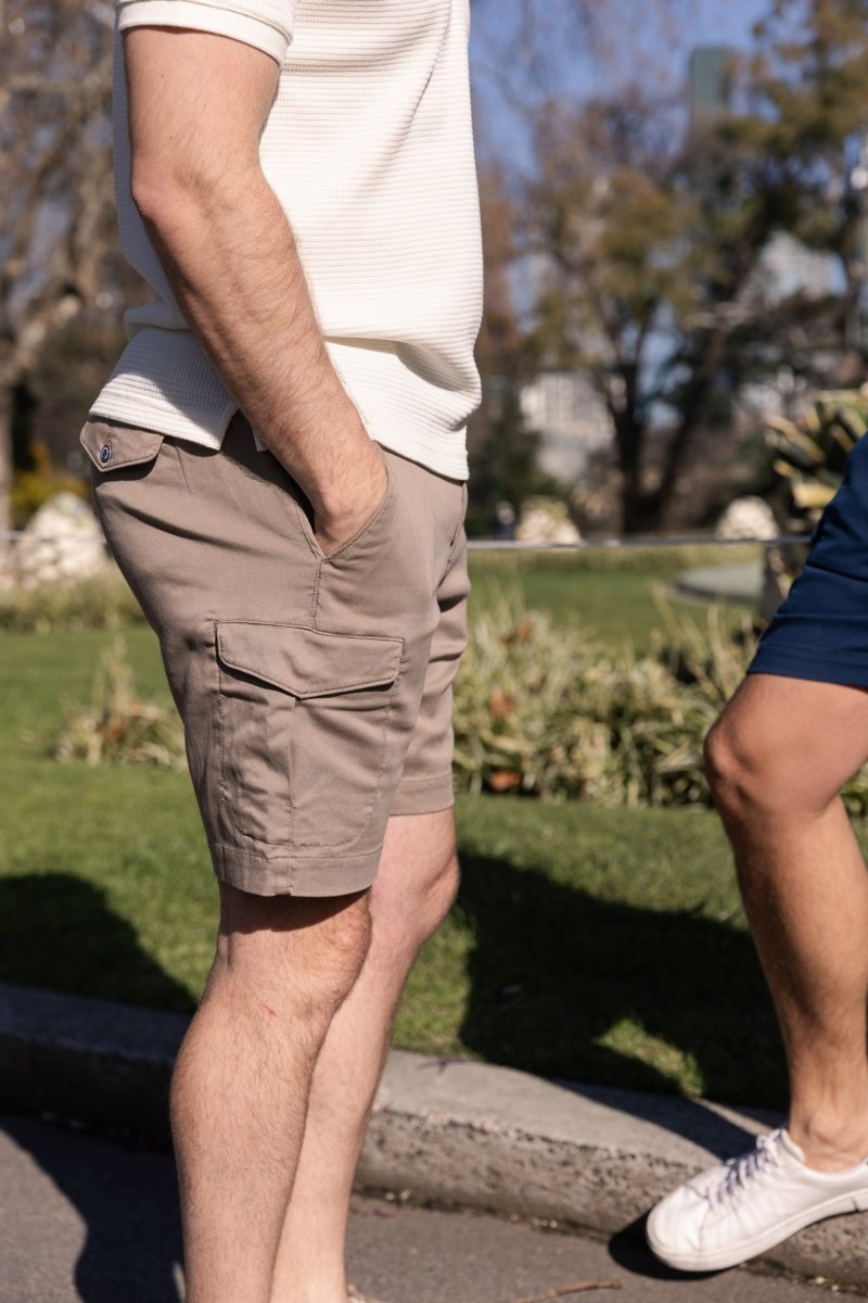 Nomads * The Aussies Frankster men's shorts in dark khaki cotton with cargo pockets worn outdoors on a sunny day