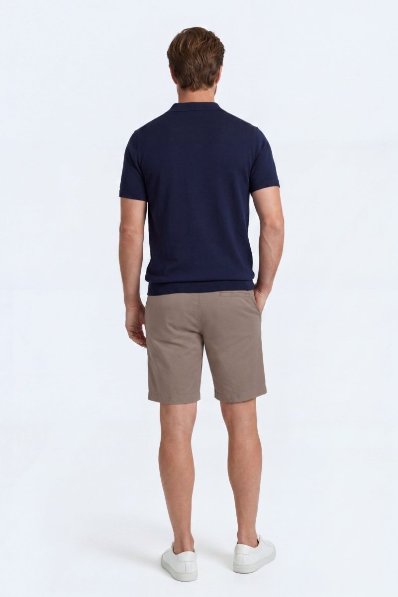 Man wearing taupe cotton men's shorts from Frankster's Nomads * The Everydays collection, paired with a navy shirt and white sneakers.