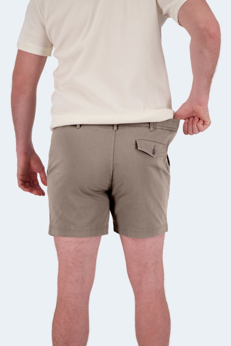 Man wearing Frankster Nomads * The Shorties dark khaki stretch cotton men's shorts pulling waistband to show fit from the back