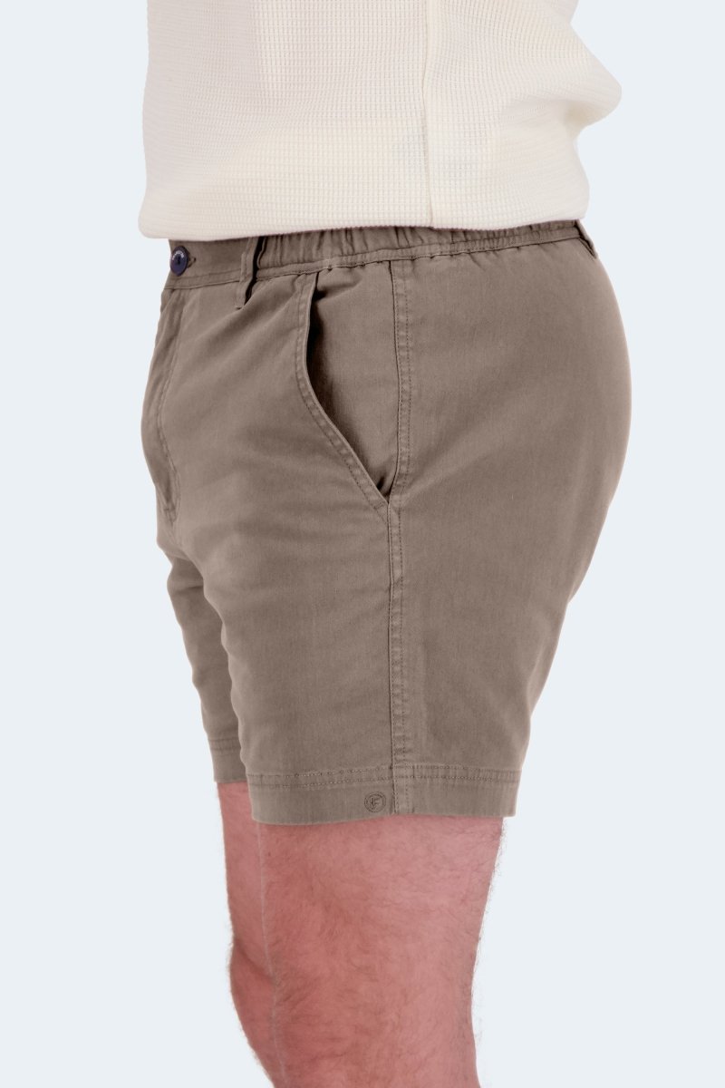 Side view of Nomads * The Shorties dark khaki stretch cotton men's shorts by Frankster worn with a cream top