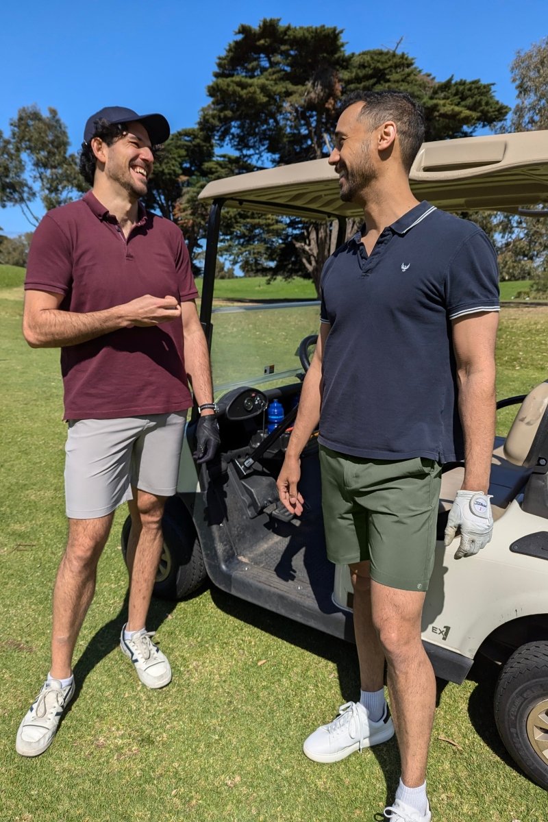 Two men wearing Frankster Rebels * The Actives men's shorts in army green and light gray lightweight fabric outdoors by golf cart