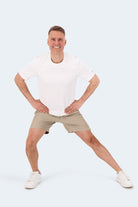 Frankster Sandbars * The Sporties Men's Shorts in beige fabric, shown on a man in a white tee during an active pose