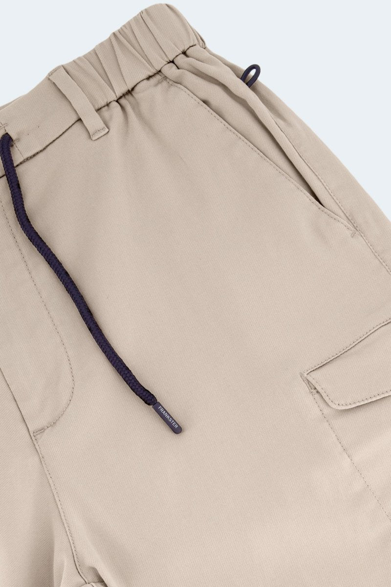 Close-up of Shores * The Aussies light khaki cotton men's shorts by Frankster with elastic waistband and navy drawstring detail