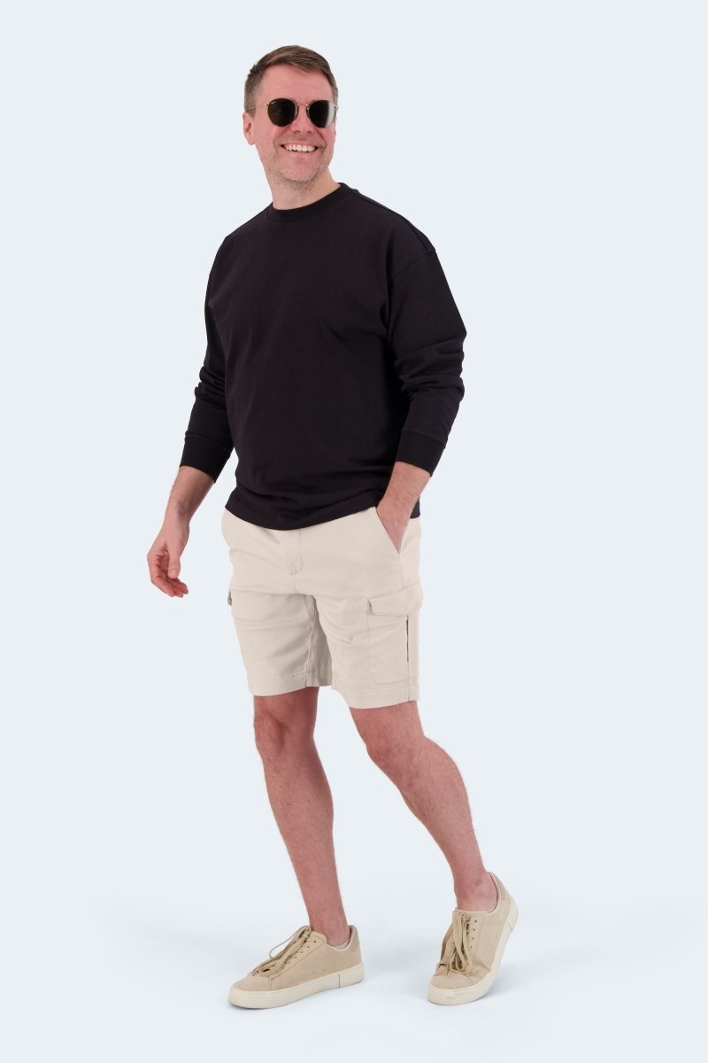 Man wearing Shores * The Aussies light khaki cotton cargo men's shorts by Frankster with beige sneakers and black long sleeve top