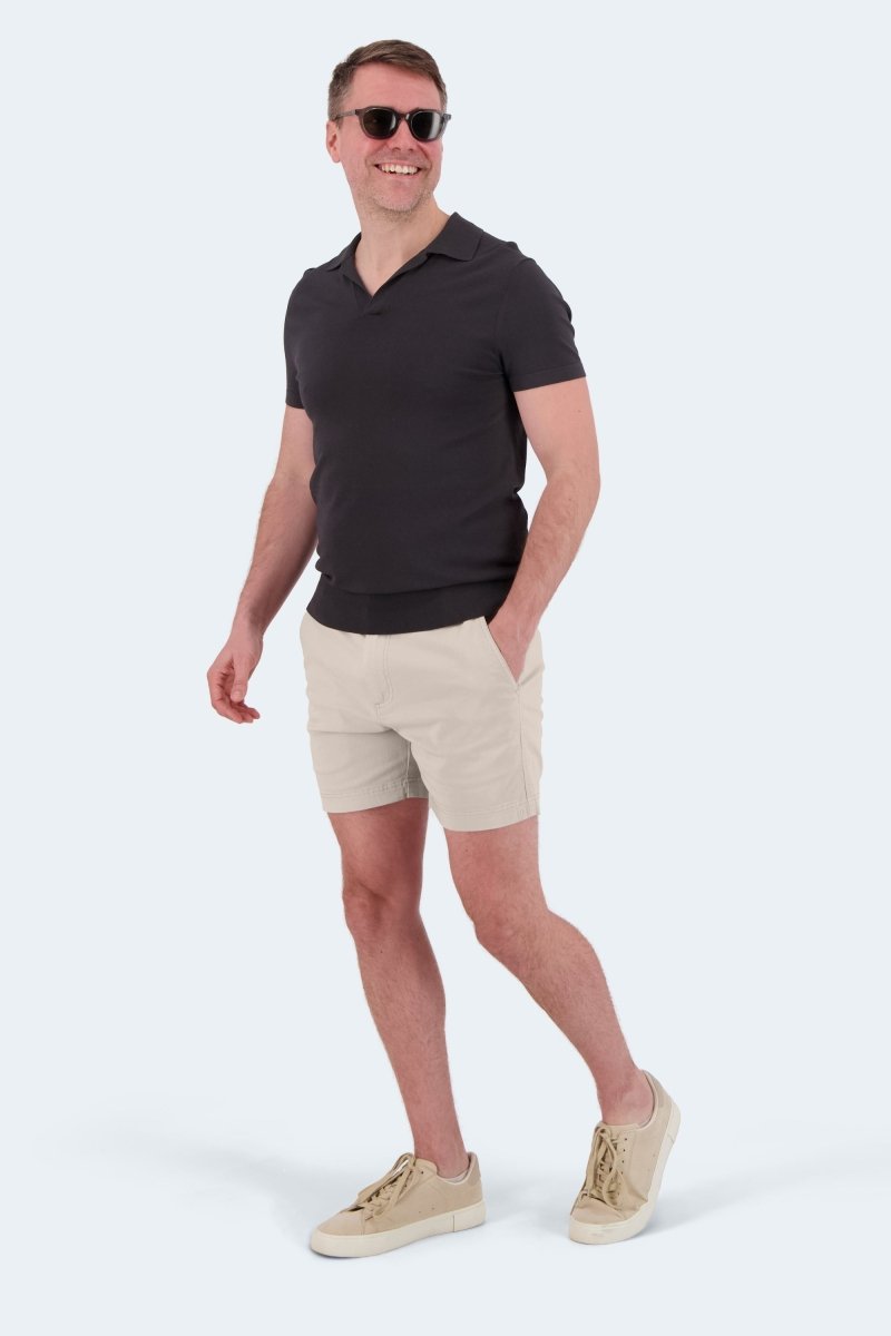 Man wearing Shores * The Shorties light khaki stretch cotton men's shorts by Frankster with black polo and beige sneakers