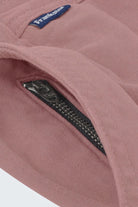Close-up of dusty pink men's shorts fabric showing a black YKK zipper on a hidden pocket, designed by Frankster for Sundowners * The Everydays, highlighting soft, durable material ideal for comfortable wear.