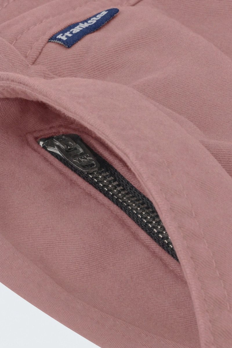 Close-up of dusty pink men's shorts fabric showing a black YKK zipper on a hidden pocket, designed by Frankster for Sundowners * The Everydays, highlighting soft, durable material ideal for comfortable wear.