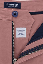 Close-up of Frankster Sundowners * The Everydays men's shorts in dusty rose colour, featuring cotton fabric, navy button and zipper detail, and inner navy lining.