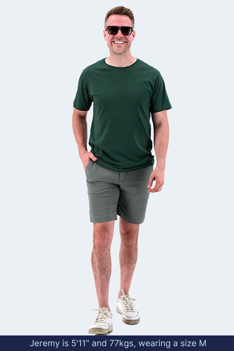 Man wearing Frankster Urbanites * The Everydays grey stretch cotton men's shorts with casual green t-shirt and sneakers