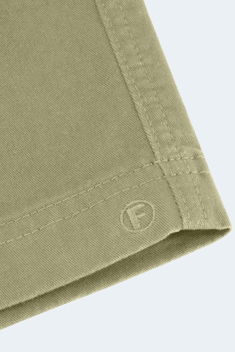 Close-up of olive green cotton fabric with stitched hem and Frankster logo on Virgins * The Everydays men's shorts