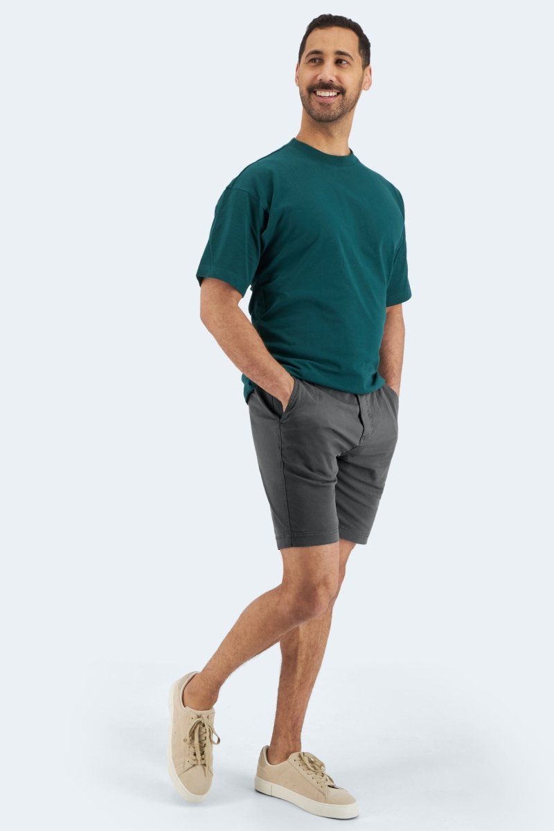 Man wearing dark grey Frankster Volcans * The Everydays men's shorts in casual cotton standing with hands in pockets