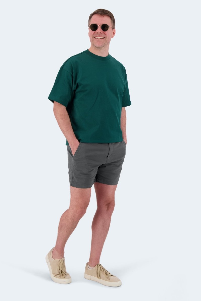 Man wearing Frankster Volcans * The Shorties dark grey stretch cotton men's shorts with green t-shirt and sneakers