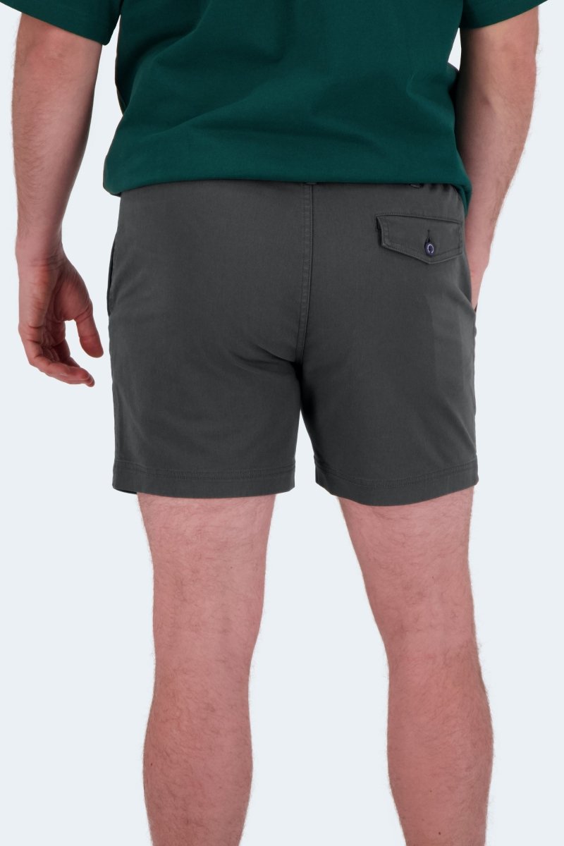Man wearing dark grey stretch cotton Volcans * The Shorties men's shorts by Frankster standing indoors showing back view